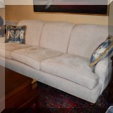 F03. Custom upholstered cream colored sofa with turned feet. 34”h x 94”w x 36”d 